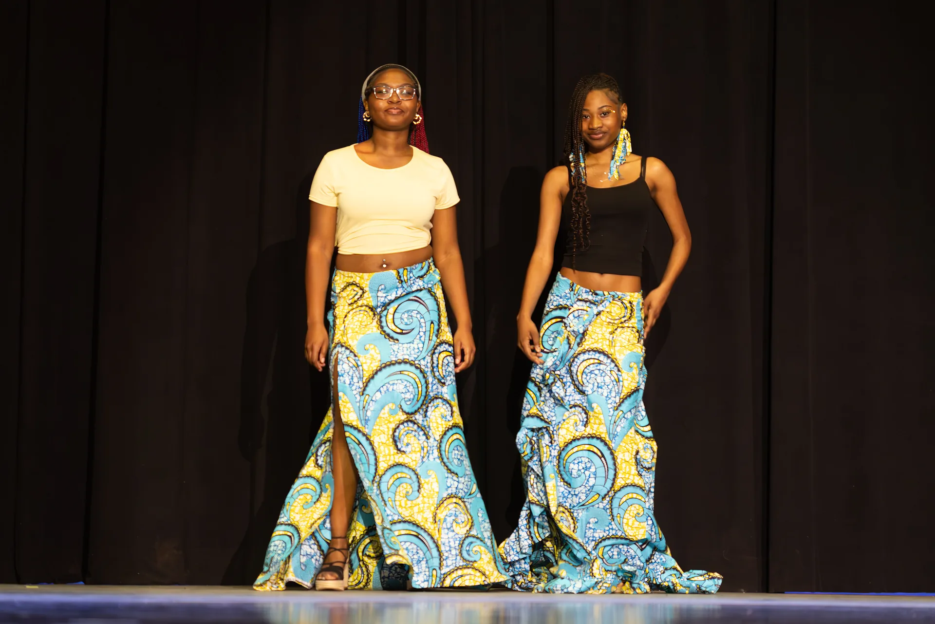 Two students in coordinating blue and gold Ankara print maxi skirts
