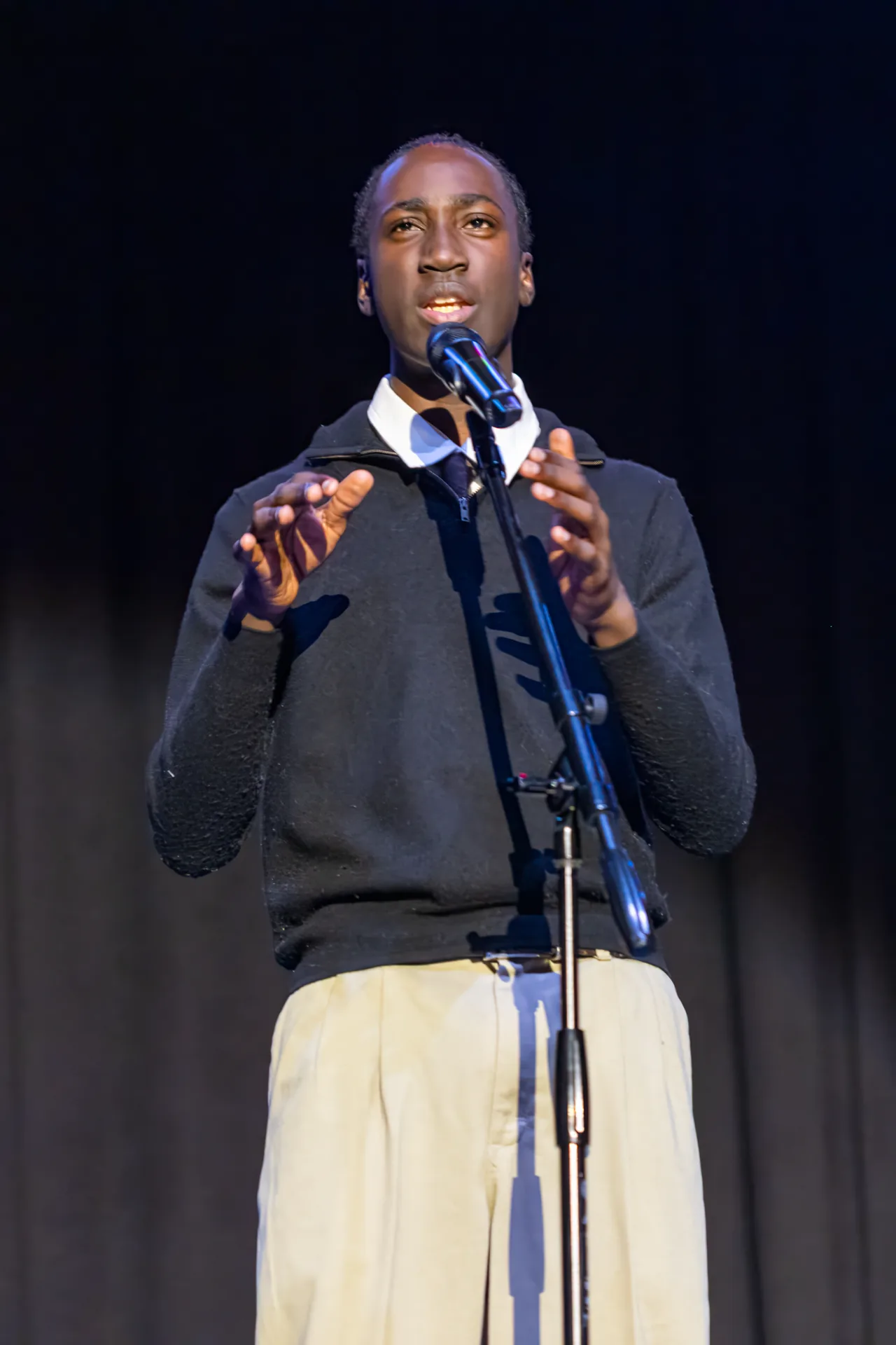 Student delivering spoken word performance at the microphone